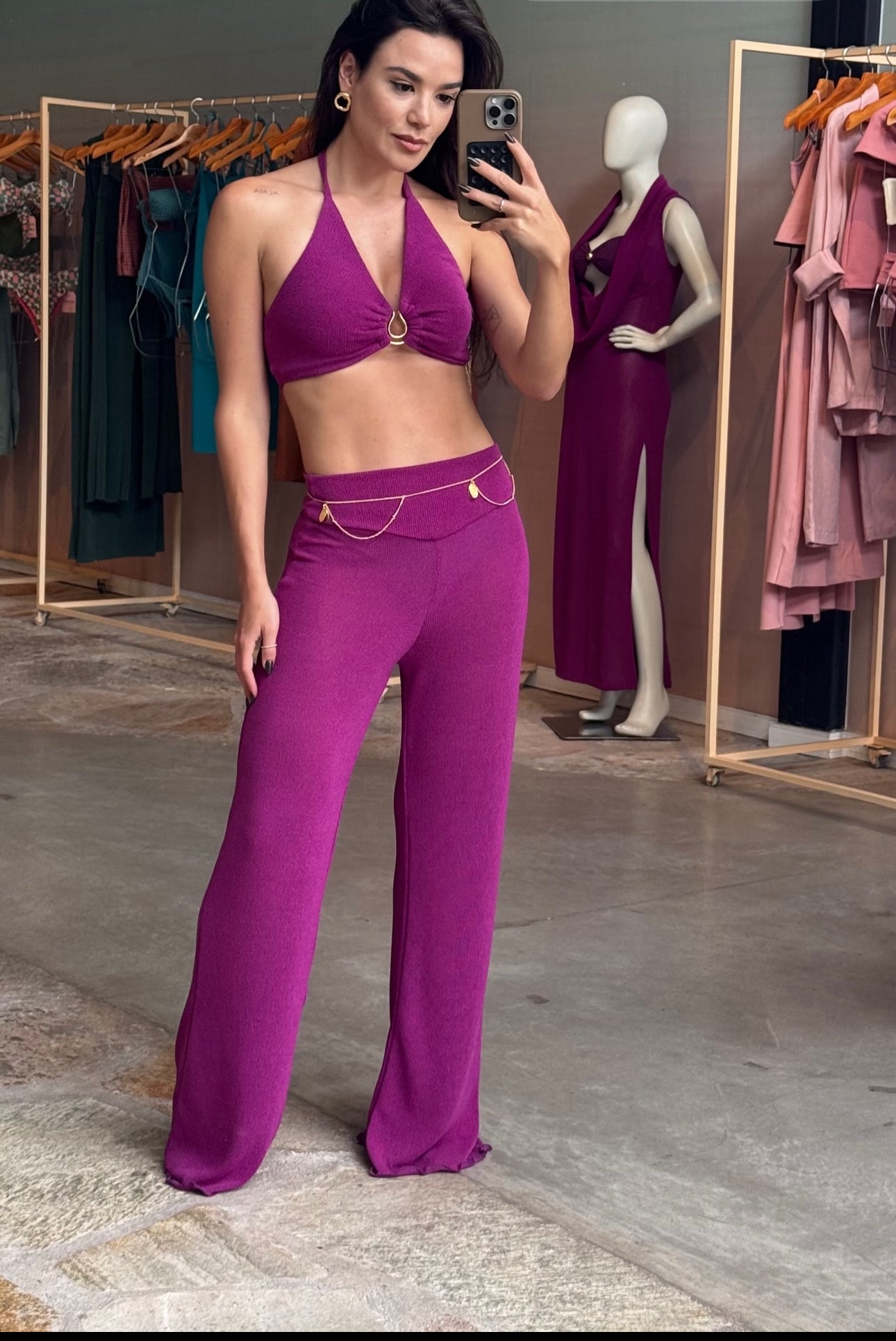 Model wearing orchid purple knit halter top and pants set with gold chain accents, perfect for beach resorts and vacation getaways.