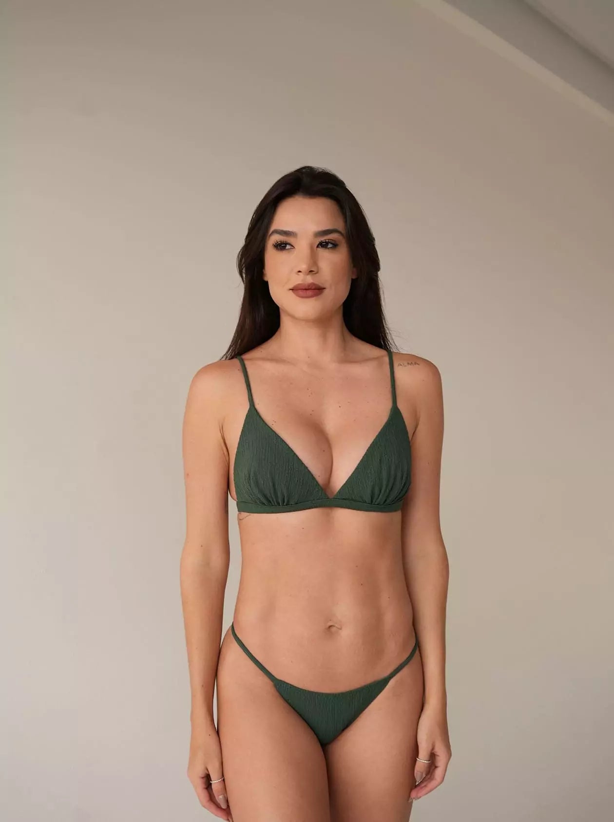 Model wearing forest green triangle bikini with bronze bottom, front pose