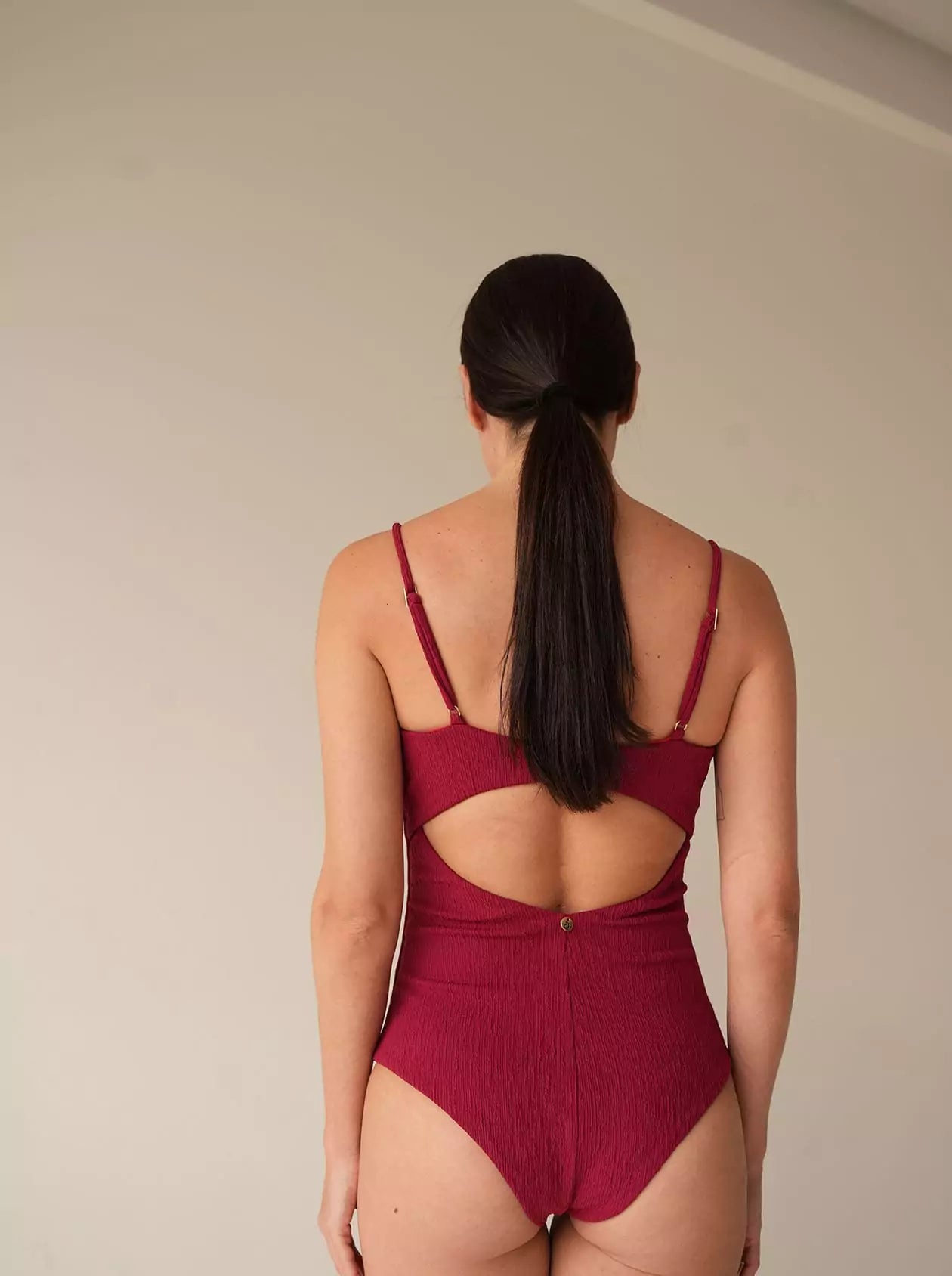 Back view of bordeaux swimsuit showing open detail and strap finish
