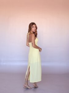 Full-length view of the Solea Halter Midi Dress in Butter Yellow with a flowing midi silhouette.