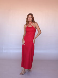 Woman wearing the Soleil Halter Linen Blend Maxi Dress in cherry red featuring an elegant halter neckline and fitted silhouette.