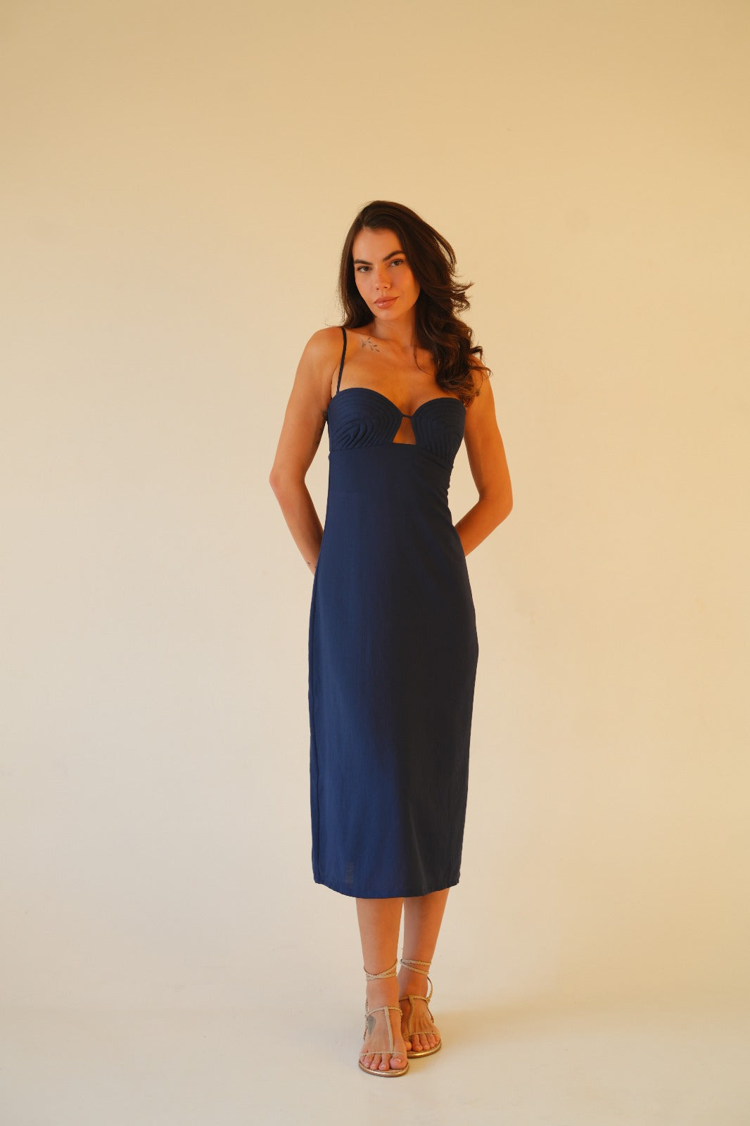 Model wearing navy blue midi dress with handcrafted sculpted bust, lace-up back and back slit – perfect for resortwear and beach vacations
