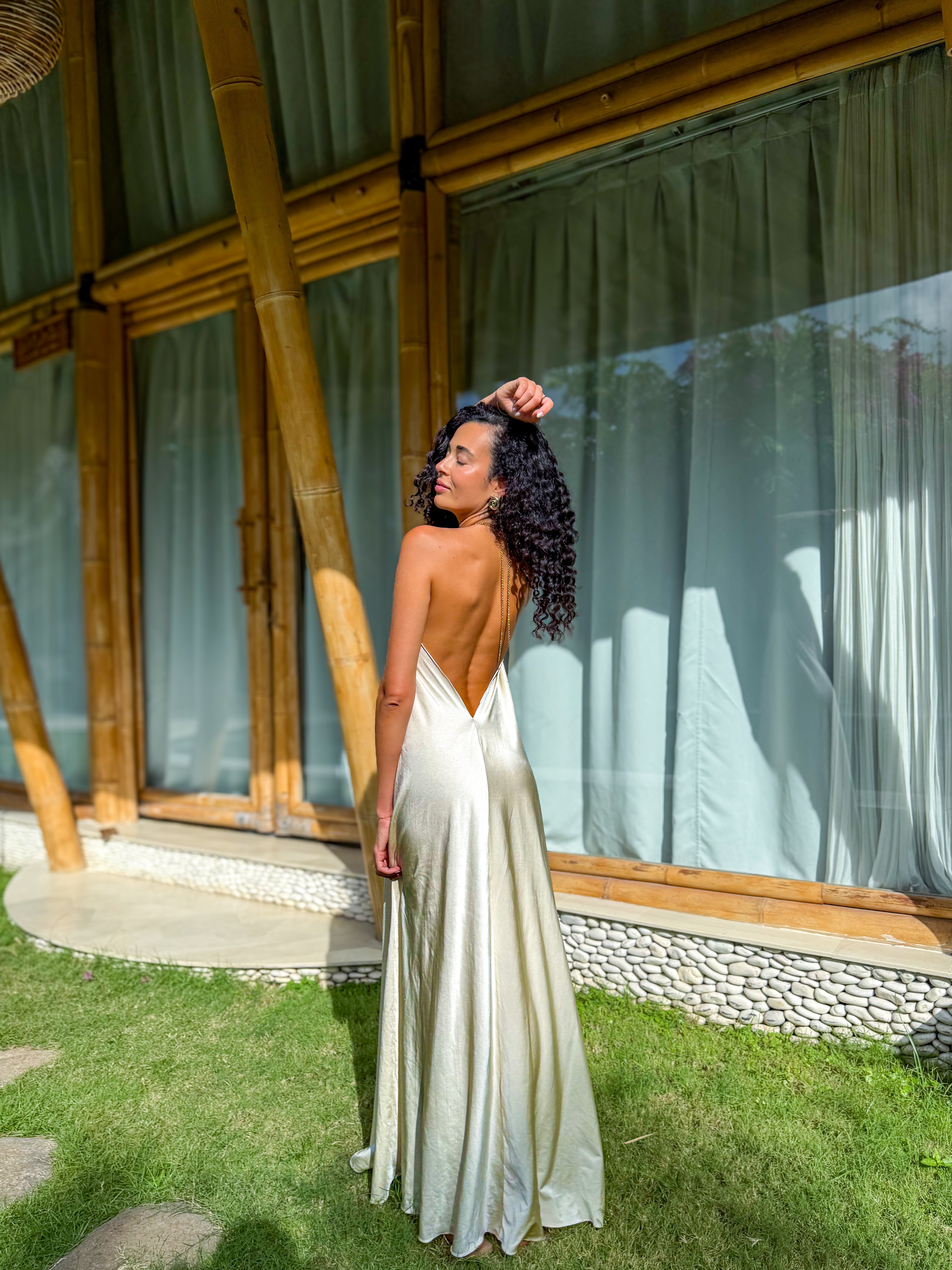 oman wearing long resort dress in viscose by Amazônia B2R; flowy maxi dress in sand tones under sunlight.