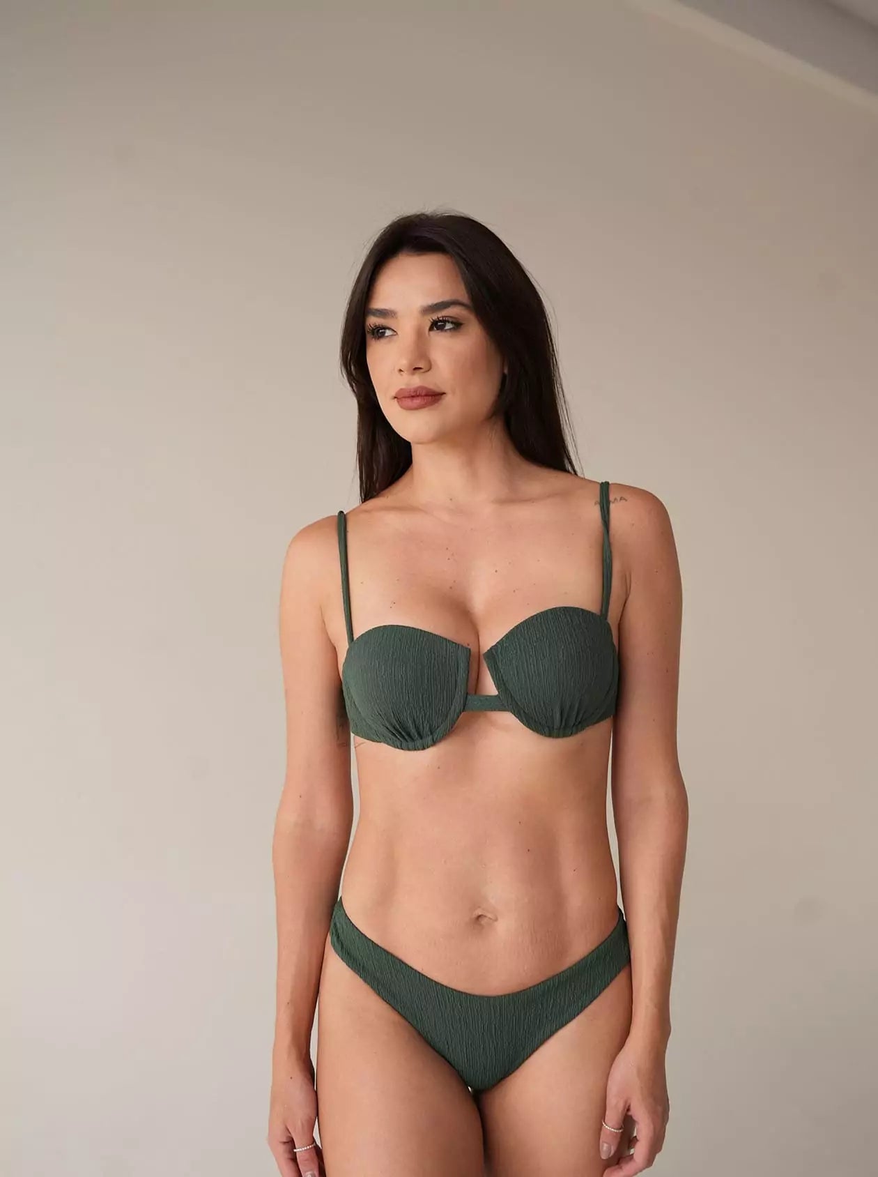 Model wearing structured green bikini in soft indoor light, clean skin and healthy look