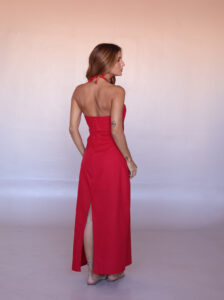 Back view of the cherry red halter maxi dress with an open back, concealed zipper and back slit.