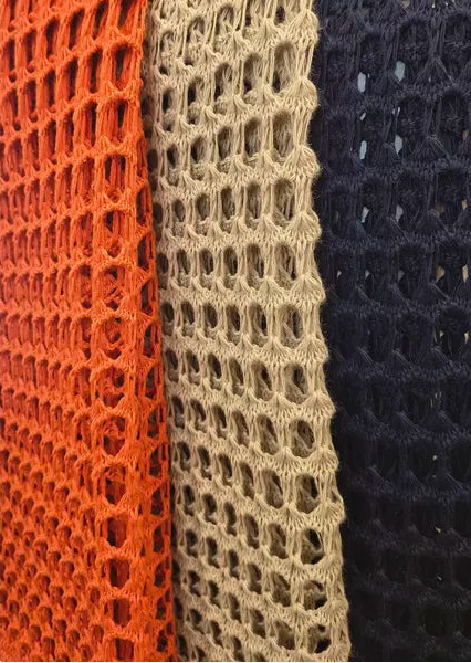 Three vertical strips of textured fabric in orange, beige, and navy on a white background.